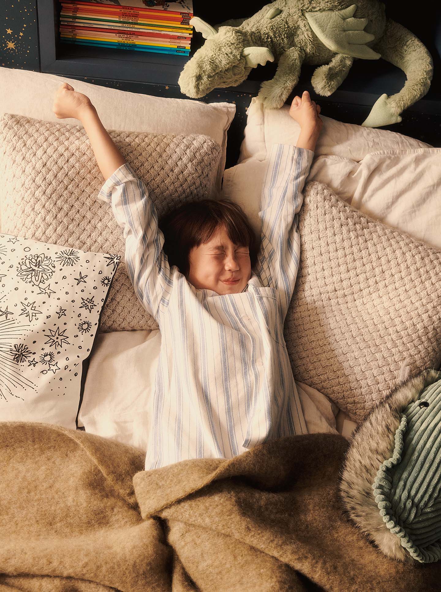 Boy stretching awake in bed