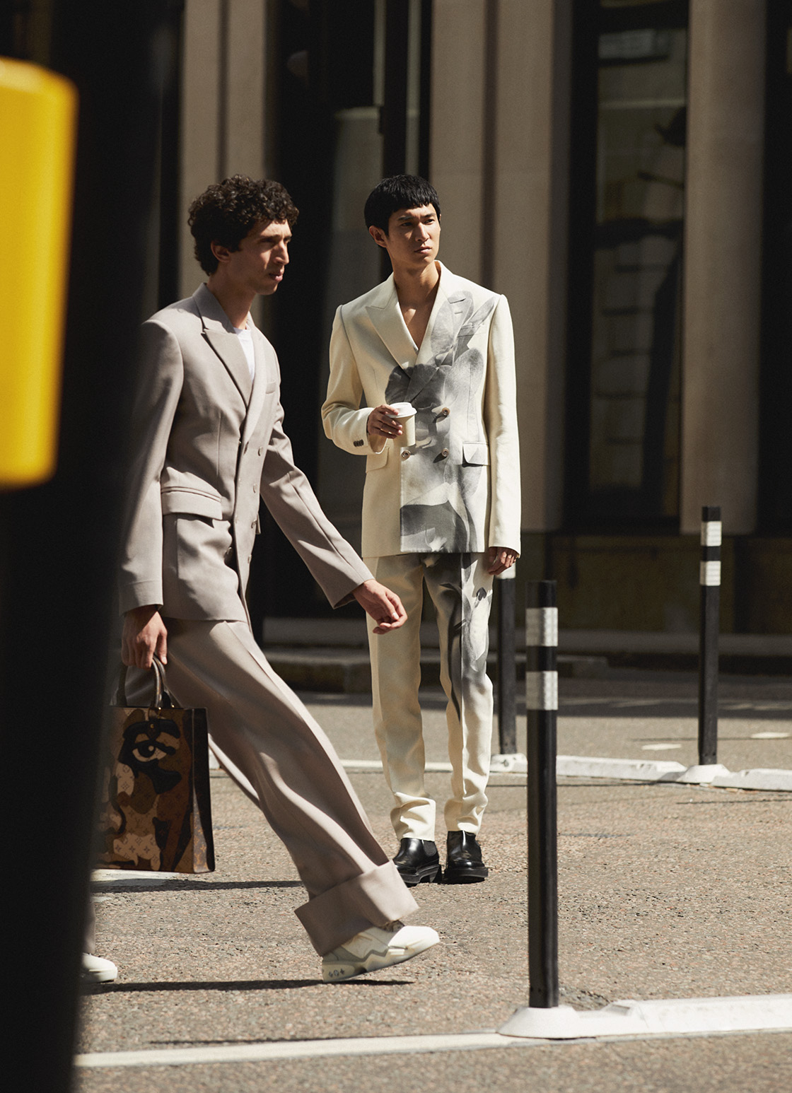 Two men walking around the street wearing monochrome suits