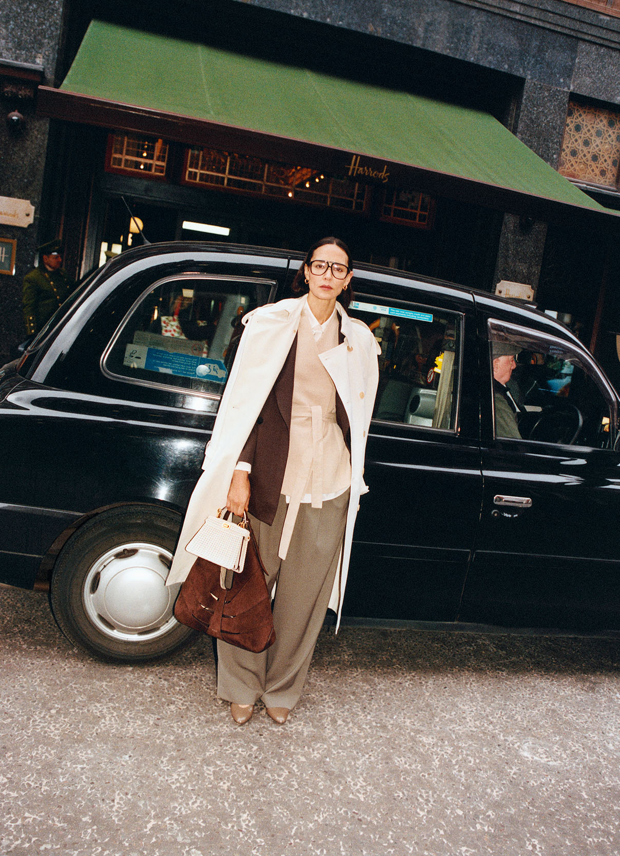 Woman exiting a taxi outside of the Harrods store wearing tailoring in shades of brown